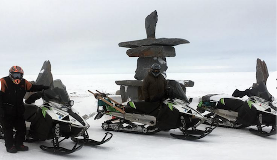 Paul Dick of Grand Rapids, Minn. (left), and Rex Hibbert of Henry, Idaho pause by a large Inukshuk, an Inuit landmark, Thursday, March 7, on the shore of Hudson Bay near Churchill, Man. Along with Rob Hallstrom of Park Rapids, Minn., the trio snowmobiled nearly 3,000 miles during a recent trek to Churchill and back from Grand Rapids. (Photo courtesy of Rob Hallstrom)