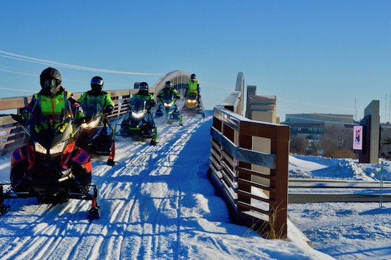 Hundreds of snowmobilers from across MN gathered at the MnUSA Winter Rendezvous. One of the several groups pictured here crosses the highway on the Paul Bunyan Trail