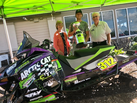 In July, Bernice and Roger Skime stand with 2020 Pro Stock Points champ Zach Herfindahl